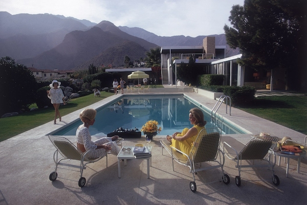 ALa celebre casa a Palm Springs progettata da Richard Neutra per Edgar Kaufman. Lita Baron siede accanto a Nelda Linsk a destra, la moglie del mercante d'arte Josef Linsk che sta parlando con un amica Helen Dzo Dzo in fondo alla piscina 1970 (Photo by Slim Aarons/Getty Images)